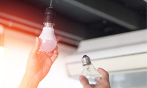 hand changing light bulb