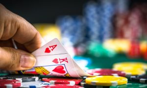Image of a poker player revealing an ace and king for a story about the live Pennsylvania poker tournament schedule this November.