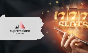 Image showing online casino gaming on a phone with a slot reel along with the PA state outline featuring the Supremeland Gaming logo for a story about the gaming manufacturer receiving interim authorization to debut in the Keystone State.