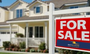 House with a "for sale" sign on the lawn. The sign has the BetRivers casino and sportsbook logo. BetRivers' parent company is considering selling. The operator ranks third among Pennsylvania online casinos and fifth among sportsbooks.