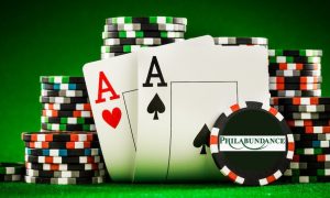 Two poker cards and a stack of poker chips. A facing poker chip has the logo for Philabundance on it. A charity poker tournament in support of Philabundance is being held at Live! Philadelphia.