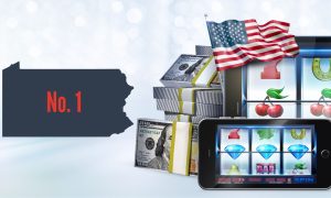 Image showing online casino gaming with slot reels on devices along with the PA state outline featuring the words "No. 1" for a story about the Keystone State solidifying itself as the top online casino market in the US this year.