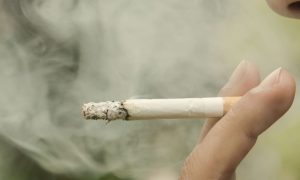 Close-up of smoking cigarette held between a man's two fingers. Americans for Nonsmokers Rights says the fact Valley Forge Casino investors even considered studying going smoke-free is a promising sign.