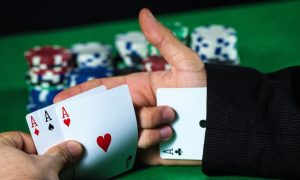 Man pulling an ace from his sleeve at a poker table. The Pennsylvania State Police have made five arrests, including a Live! Casino Philadelphia dealer, in an alleged $170,000 cheating scam.